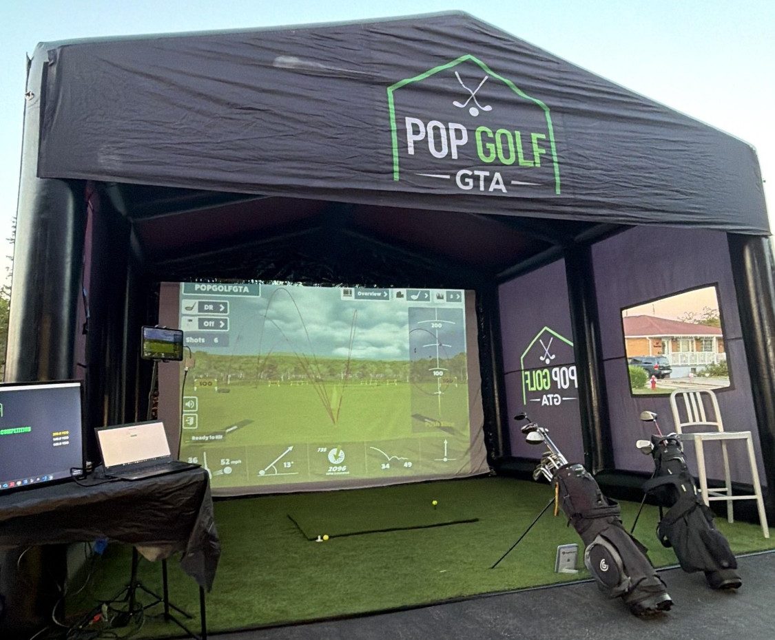 Pop Golf GTA simulator fully set up: branded enclosure, projector screen with live shot data, hitting mat and golf clubs